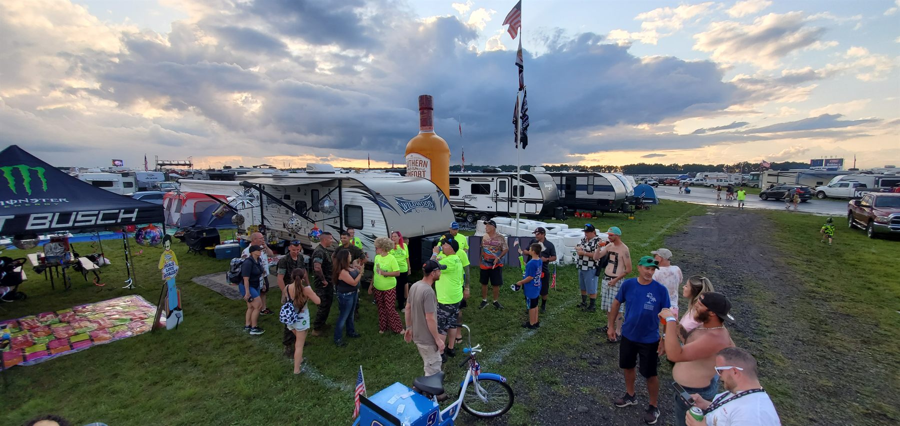 Skyline of telescoping flagpoles at dusk camp party